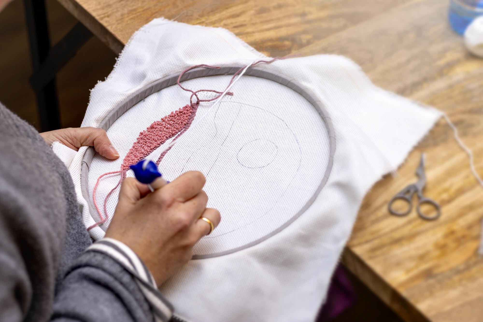 Warsztat z haftującą ręką i tamborkiem